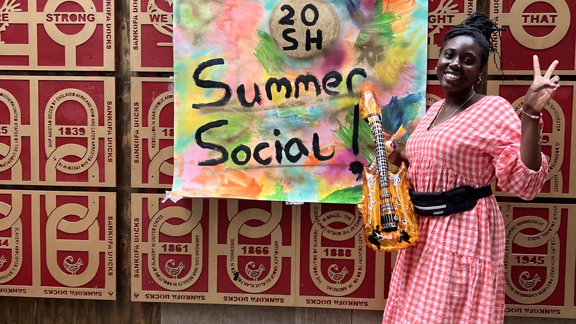 A person smiling with a sign that says 'Summer Social 2025'